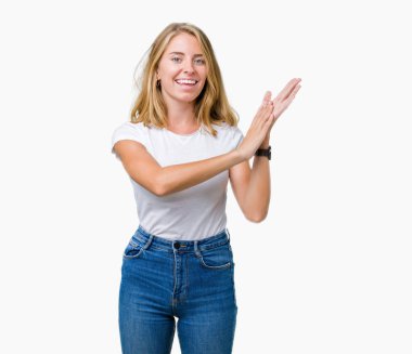 Casual beyaz t-shirt üzerinde izole giyen güzel genç kadın arka plan Clapping ve mutlu ve neşeli, gururlu gülümseyen birlikte eller alkış