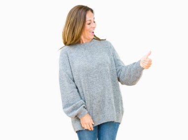 Jest tarafa gurur, seyir izole arka plan üzerinde kış kazak giyen güzel orta yaş kadın yapıyor gülümseyen yaşasın