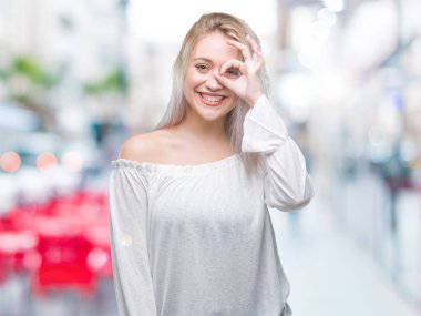 Sarışın genç kadın gülümsüyor, parmakları ile mutlu yüz üzerinden seyir göz el ile ok jest yapıyor izole arka plan üzerinde.