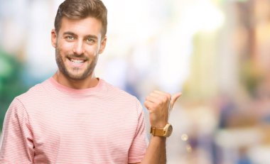 Yakışıklı delikanlı arıyor ve başparmak yanında yukarıyı mutlu yüz ile gülümseyen izole arka plan üzerinde.