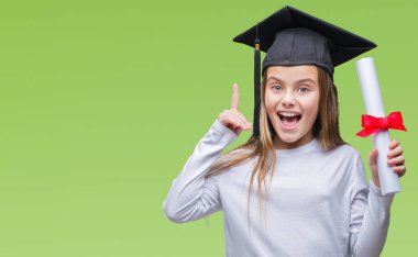 Genç güzel kız derecesi izole arka plan üzerinde tutarak lisansüstü şapkası bir fikir ya da soru işaret parmağı gülen yüz, bir numara ile şaşırttı