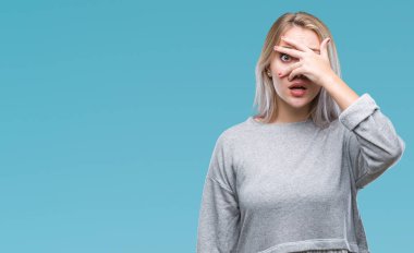 Mahcup ifadeyle parmaklarımın arasından seyir izole arka yüz ve gözler el ile kapsayan şok bakmak genç sarışın kadın.