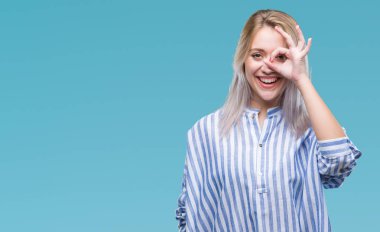 Sarışın genç kadın gülümsüyor, parmakları ile mutlu yüz üzerinden seyir göz el ile ok jest yapıyor izole arka plan üzerinde.