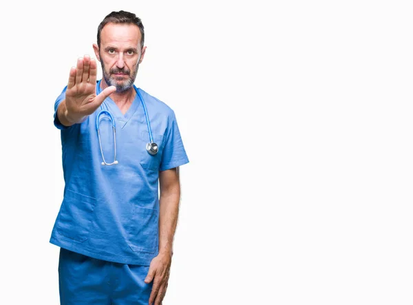 中年白发高级医生在孤立的背景下穿着医疗制服做停止用手掌唱歌 脸上带有负面和严肃手势的警告表情 — 图库照片
