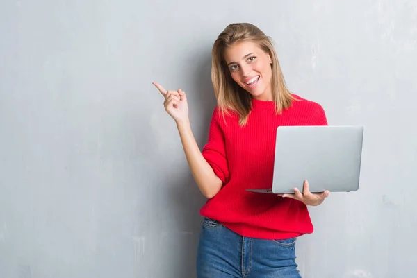 Hermosa Mujer Joven Sobre Pared Gris Grunge Usando Computadora Portátil —  Fotos de Stock