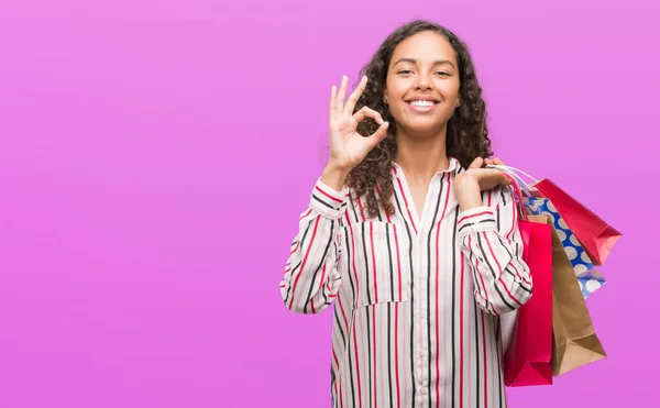 Junge Hispanische Frau Mit Einkaufstaschen Tut Zeichen Mit Fingern Ausgezeichnetes — Stockfoto