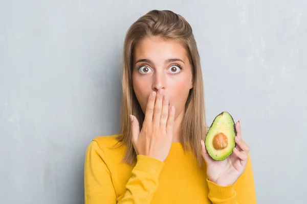 Beautiful Young Woman Grunge Grey Wall Eating Avocado Cover Mouth — Stock Photo, Image