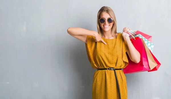 Hermosa Mujer Joven Sobre Pared Gris Grunge Sosteniendo Bolsas Compras — Foto de Stock