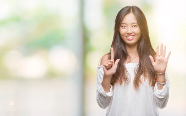 年轻的亚洲妇女在孤立的背景显示和指向手指数七 而微笑着自信和快乐 — 图库照片