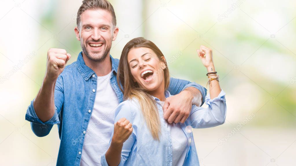 Young couple in love over isolated background very happy and excited doing winner gesture with arms raised, smiling and screaming for success. Celebration concept.