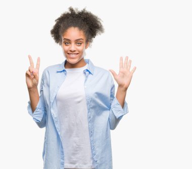 Genç afro Amerikan kadın gösterilen ve parmakları ile işaret izole arka plan yüzünden kendinden emin ve mutlu gülümseyerek süre yedi numara.
