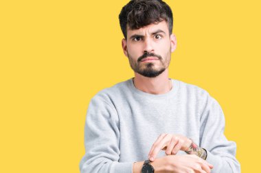 Acele işaretleme izlemek için zaman, sabırsızlık, üzgün ve kızgın son tarih gecikme için izole arka plan üzerinde sweatshirt giyen genç yakışıklı adam