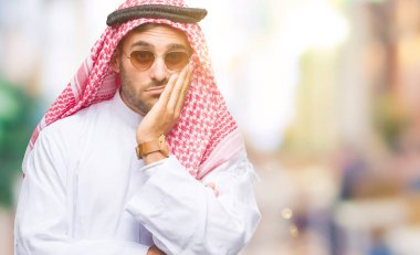 Keffiyeh seyir yorgun ve bıkkın ile depresyon sorun Çapraz kollar ile izole arka plan düşünme üzerinde giyen genç yakışıklı adam.