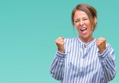 Gülümseyen ve başarı için çığlık orta yaş üst düzey İspanyol kadın izole arka plan çok mutlu ve heyecanlı kaldırdı, silah ile kazanan jest yapıyor. Kutlama kavramı.