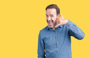 Yakışıklı orta yaş zarif komuta sizde yapıyor gülümseyen izole arka plan üzerinde telefon hareketi ile el ve parmak telefonda konuşuyor gibi. Kavramları iletişim.