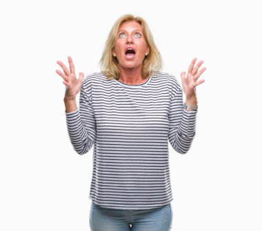 Orta yaş sarışın kadın izole arka plan çılgın ve kızgın bağırarak ve agresif ifade ve silah kaldırdı bağırıyor. Hayal kırıklığı kavramı.