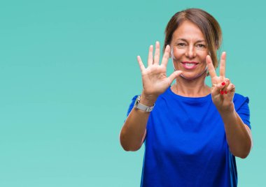 Orta yaş üst düzey İspanyol kadın gösterilen ve parmakları ile işaret izole arka plan yüzünden kendinden emin ve mutlu gülümseyerek süre yedi numara.