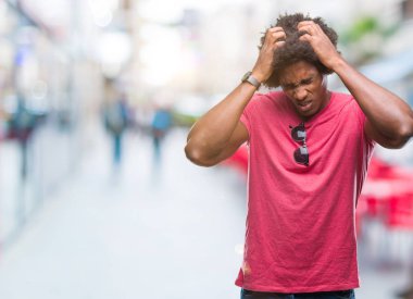 Afro Amerikalı adam çünkü umutsuz ve stresli baş ağrısı acı izole arka plan üzerinde ağrı ve migren. Ellerini kafasına.