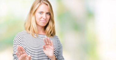 İzole arka plan üzerinde çizgili süveter giyen güzel genç kadın tiksinti ifadesi, memnun ve korkulu tiksinti yüz yapıyorsun çünkü nefret tepki. Elleriyle kaldırdı. Sinir bozucu kavramı.