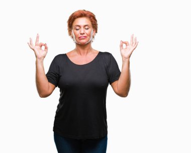 Atrractive üst düzey beyaz Kızıl saçlı kadın izole arka plan üzerinde dinlenmek ve gülümseyen gözlerle parmak ile meditasyon jest yapıyor kapalı. Yoga kavramı.