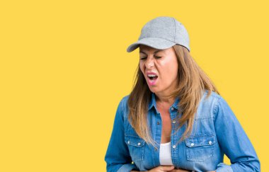 Güzel orta yaş kadın üzerinde spor şapkası izole mide üzerinde el ile arka plan çünkü hazımsızlık, ağrılı hastalık hasta hissediyor. Ağrısı kavramı.