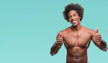 Afro Amerikalı gömleksiz adam çıplak vücut izole arka plan başarı işareti el ile pozitif jest yapıyor üzerinde gösterilen başparmak gülümseyen ve mutlu. Neşeli bir ifadeyle, kazanan jest kameraya bakıyor.