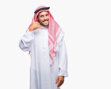Yakışıklı delikanlı keffiyeh yapıyor gülümseyen izole arka plan üzerinde giyen telefon hareketi ile el ve parmak telefonda konuşuyor gibi. Kavramları iletişim.