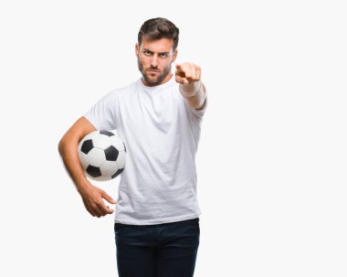 Yakışıklı delikanlı futbol futbol topu tutan kamera ve size parmak ile işaret arka plan izole, el işareti, pozitif ve kendinden emin bir jest ön