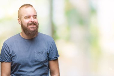 İzole arka plan uzak tarafına gülümseme ile yüzünde, doğal ifade seyir üzerinde genç beyaz hipster adam. Kendine güvenen gülüyor.