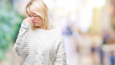 Kış kazak ve gözlük izole arka plan yorgun sürtünme burun ve göz yorgunluğu ve baş ağrısı duygu üzerinde giyen genç güzel sarışın kadın. Stres ve hayal kırıklığı kavramı.