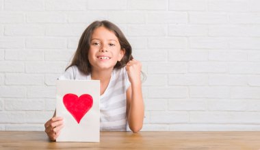 Duygu tezahürat gurur çığlık ve zafer ve başarı çok heyecanlı, kutluyor tablo veren anne gün kart üzerinde oturan genç İspanyol çocuk