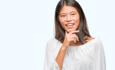 Genç Asyalı kadın emin çapraz kollar ve çeneme kaldırdı el ile gülümseme ile kameraya bakarak izole arka plan üzerinde. Pozitif düşünce.