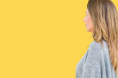 Güzel orta yaş kadın giyiyor kış kazak izole arka tarafına, seyir üzerinde dinlenmek doğal yüz emin gülümseme ile pozuyla profili.