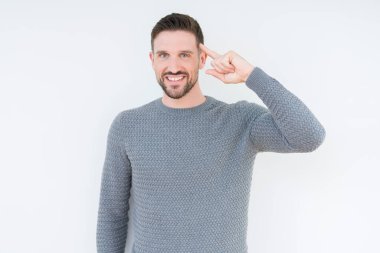 Casual kazak izole üzerinde giyen genç yakışıklı adam arka plan bir parmak, harika bir fikir ya da düşünce, iyi bellek ile baş gösteren gülen