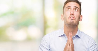 Yalvarıyor ve umut ifade yüzünde çok duygusal ve endişe ile birlikte elleriyle dua yakışıklı genç bir işadamı. Bağışlanmak. Din kavramı.