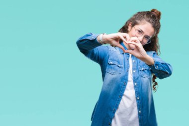 Güzel genç esmer kıvırcık saçlı kız aşık kalp simgesi ve elleriyle şekil gösteren gülümseyen izole arka plan üzerinde gözlük takıyorum. Romantik kavramı.