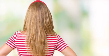 Rahat giyen güzel orta yaş kadın t-shirt üzerinde geriye doğru uzakta silah ile vücut üzerinde seyir izole arka plan ayakta çizgili