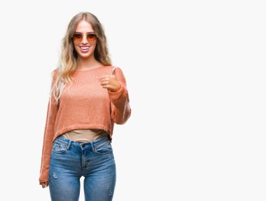 Güzel genç sarışın kadın hareketi el ile mutlu yaşasın yapıyor izole arka plan üzerinde güneş gözlüğü takıyor. Kameraya bakarak başarı gösteren ile ifade onaylama.