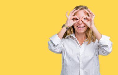 Güzel genç iş kadını, dilini parmaklarının arasından baktığını yapışmasını dürbün gibi ok jest yapıyor izole arka plan üzerinde. Deli ifade.