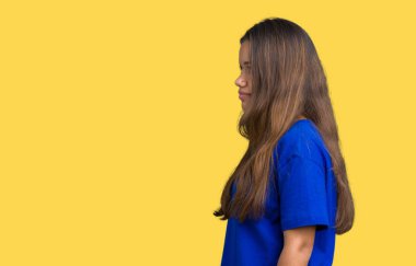 İzole arka tarafına, seyir üzerinde mavi t-shirt giyen genç güzel esmer kadın dinlenmek doğal yüz emin gülümseme ile pozuyla profili.