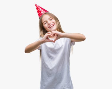 Genç güzel kız aşık kalp simgesi ve elleriyle şekil gösteren gülümseyen izole arka plan üzerinde Doğum günü şapkası. Romantik kavramı.