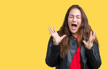 Güzel artı boyutu genç kadın deli ve silah ile başarı için deli kutluyor izole arka plan üzerinde bir moda deri ceket giyiyor kaldırdı ve heyecanlı çığlık gözler kapalı. Kazanan kavramı