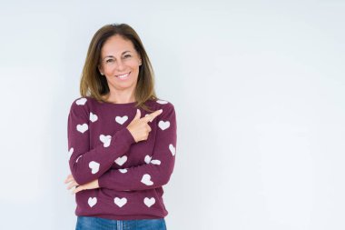 İzole arka neşeli bir gülümseme ile el ve parmak kadar yan yüzünde mutlu ve doğal ifade ile işaret yüz üzerinde kalp kazak giyen güzel orta yaş kadın