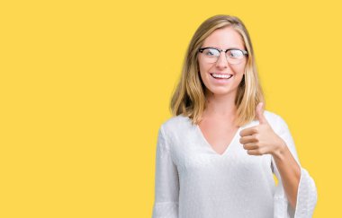 Güzel genç kadın hareketi el ile mutlu yaşasın yapıyor izole arka plan üzerinde gözlük takıyorum. Kameraya bakarak başarı gösteren ile ifade onaylama.