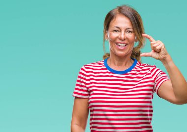 Orta yaş İspanyol kadın kıdemli izole arka plan gülümseyen ve süre seyir ve kamera boyutu işaret parmaklarıyla yapıyor el ile kendinden emin eller üzerinde. Ölçü kavramı.