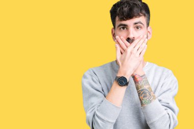 Üzerine tişört giyen genç yakışıklı adam arka plan ağız hata için elleriyle kapsayan şok izole. Gizli kavramı.