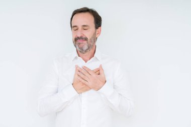 Göğüs kapalı gözler ve yüzünde minnettar jest ile gülümseyen izole arka plan üzerinde zarif komuta sizde eller. Sağlık kavramı.