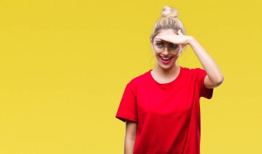 Kırmızı t-shirt ve gözlük üzerinde giyen genç güzel sarışın kadın arka plan çok mutlu ve gülümseyen uzakta el ile üzerine kafa seyir izole. Arama kavramı.