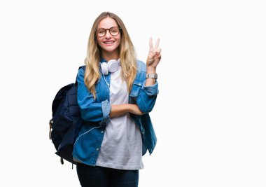 Mutlu yüz zafer işareti yaparken kameraya göz kırpıyor ile gülümseyen izole arka plan üzerinde kulaklık ve gözlük giyen genç güzel sarışın öğrenci kadın. İki numaralı.