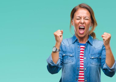 Orta yaş üst düzey İspanyol kadın yüzünden kızgın ve silah ile başarı için deli kutluyor izole arka plan ortaya çıkar ve heyecanlı çığlık gözler kapalı. Kazanan kavramı